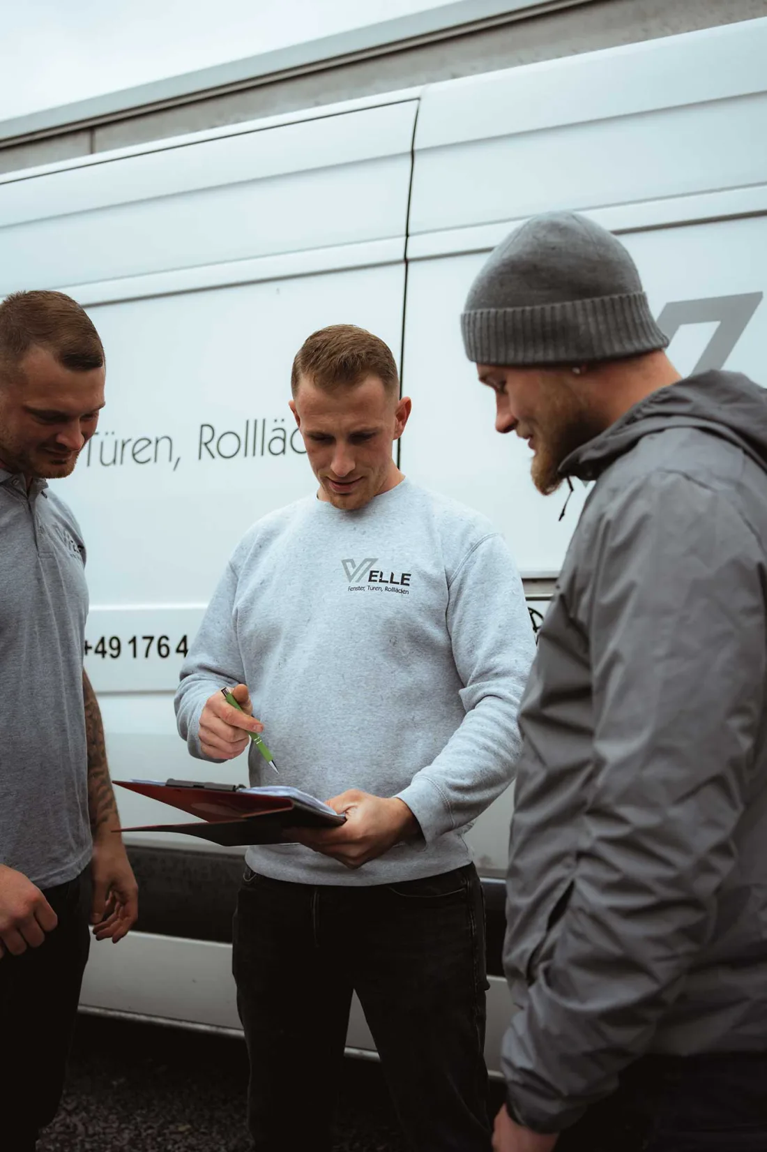 Das Team von Fensterbau Velle bespricht einen Auftrag am Firmenwagen